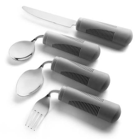 Older person using adaptive utensils at home